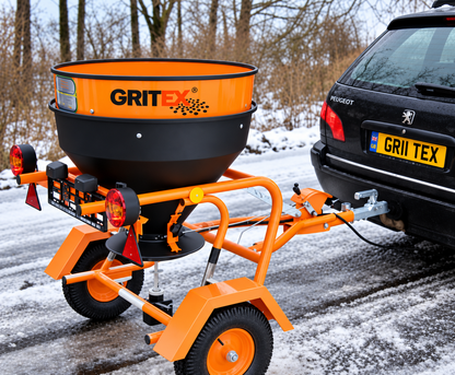 GRITEX Fuji towable salt spreader behind a Peugeot in a snowy setting