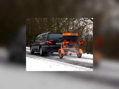 Fuji 250kg towable salt spreader operating on snowy road